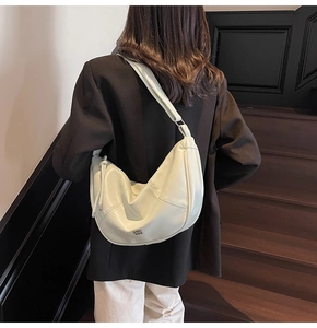 Vue latérale détaillée du sac bandoulière croissant vert menthe avec coutures sur modèle