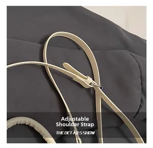 Gros plan sur la bandoulière réglable en cuir crème avec boucle métallique argentée