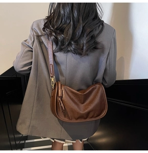 Side view of vintage brown pleated leather crossbody bag with tassel and gold hardware