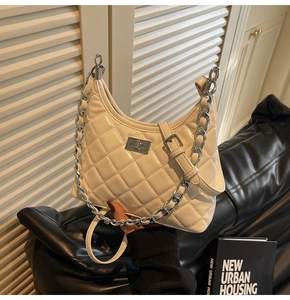 Detail of quilted beige handbag with glossy PU leather and chunky silver chain strap