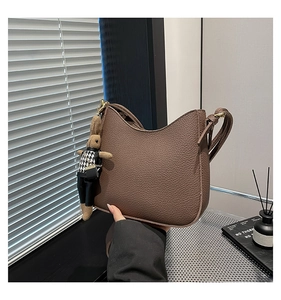 Détail du sac hobo en cuir grainé marron foncé avec un pendentif lapin mignon