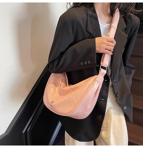 Détail du sac demi-lune rose montrant la texture mate et le design plissé