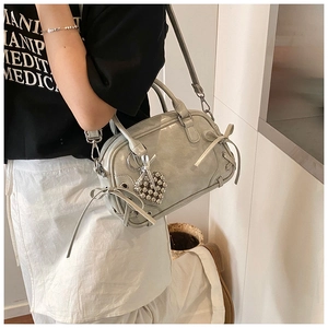 Detail der Boston Bag mit Schleifen und Herzanhänger, von Model schräg getragen
