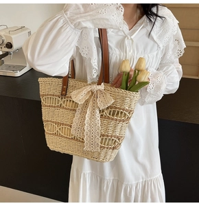 Detailed texture of hand-woven straw tote with elegant lace bow and leather handle