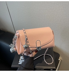 Detail of light pink oil wax leather bag with silver chain strap and metal ball charm
