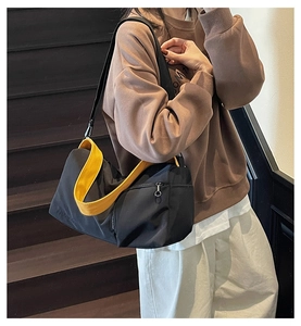 Détail du sac Boston en toile avec doublure jaune contrastée et tirette de zip en anneau