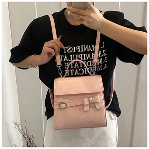 Roze mini-rugzak met strik gedragen door model met zilveren gesp en chic ontwerp