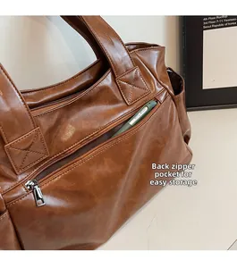 Close-up of the back zipper pocket on a brown tote bag showing phone storage detail
