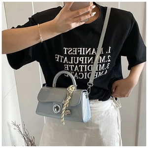 Détail du sac bandoulière en cuir verni bleu clair avec foulard et fermoir métal