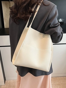 Minimalist off-white tote bag with lychee texture for women shown in lifestyle setting
