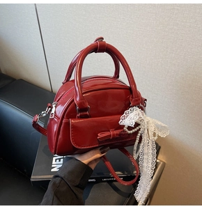 Detail of dark red glossy bowling bag with pearl chain and lace bow decorations