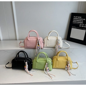 Detail of five colorful lychee pattern mini boston bags on marble display steps