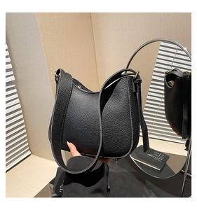 Détail du sac demi-lune en cuir noir grainé avec ferrures dorées et bandoulière