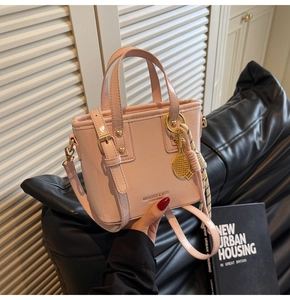 Detail of pink leather bucket bag with tennis racket charm and woven rope detail