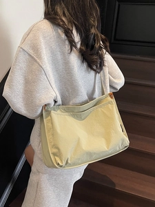 Light green canvas tote bag for women shown with casual grey outfit on stairs