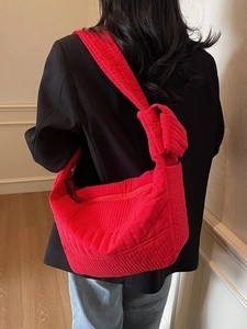 Large red quilted nylon shoulder bag with knotted strap and secure zip closure