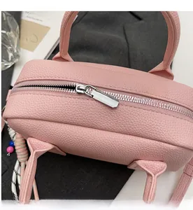 Detail of pink lychee textured leather bag showing smooth silver metal zipper closure