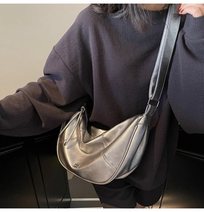 Détail du sac croissant argenté métallisé avec large bandoulière et accents de cordon