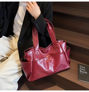Burgundy tote bag styled on model with black blazer for elegant daily commuting