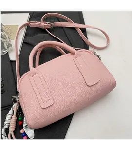 Detailed macro view of pink litchi grain leather bag with a stylish smiley face charm