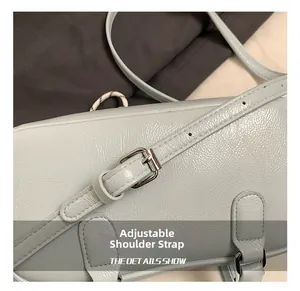 Detail of adjustable leather shoulder strap with silver buckle on light blue handbag