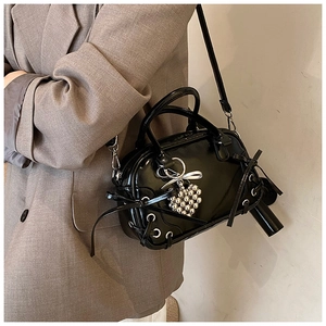 Detail der glänzenden schwarzen Lackleder-Boston-Bag mit Schnürung und Herzanhänger