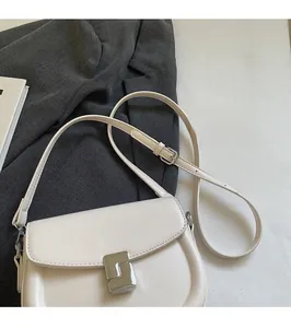 Detail view of cream leather saddle bag with silver buckle and adjustable shoulder strap