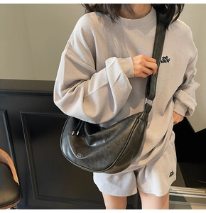 Détail du sac bandoulière croissant noir minimaliste avec texture cuir mat