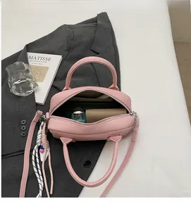 Detail view of pink pebbled leather bag interior with zipper and spacious capacity