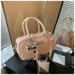 Close-up of pink Boston bag showing silver hardware and decorative charm detail