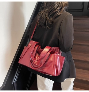 Detailed view of deep red tote bag with dual handles and adjustable shoulder strap