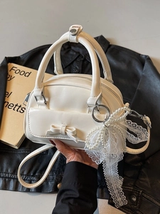 Chic white bowling handbag with bow detail and pearl charm for women, crossbody style