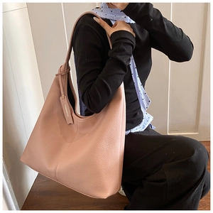Detail of pink lychee textured tote bag showing supple leather and leather brand tag