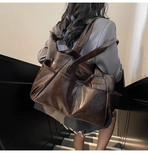 Detailed view of dark brown vintage faux leather tote bag with functional side pockets