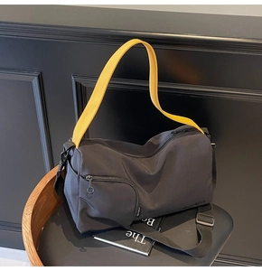 Détail du sac Boston en toile avec bandoulière jaune et fermeture éclair à anneau