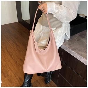 Detailed texture of pink lychee grain leather on a large capacity hobo shoulder bag