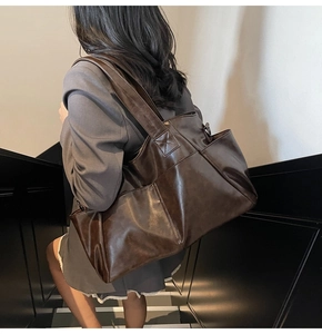 Deep coffee large tote bag with wide strap shown on model in a staircase setting