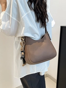 Sac hobo en cuir grainé marron avec charm lapin mignon porté à l'épaule