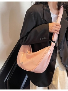 Sac à bandoulière demi-lune en cuir rose avec sangle large et logo métallique