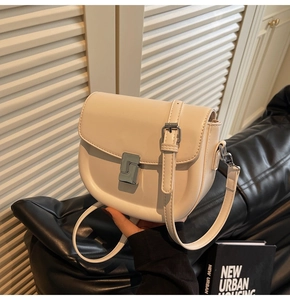 Close-up of cream white saddle bag showing smooth texture and silver square buckle
