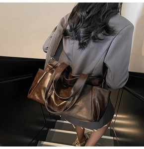 Detailed side view of a large brown leather tote bag with shoulder strap and side pocket