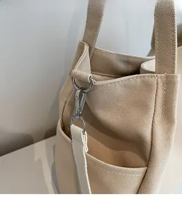 Dettaglio della borsa tote in tela beige con anello a D in metallo e tracolla rinforzata