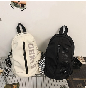 Close-up of side pockets and BTXBD lettering on black and cream crossbody sling bags