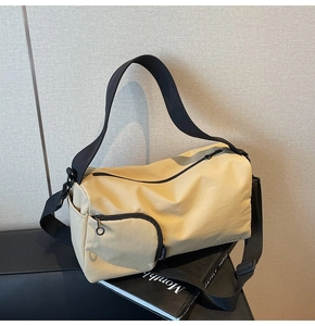 Détail du sac Boston en toile beige avec poche latérale zippée et étiquette de marque