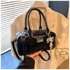 Detail view of a black glossy Boston bag with silver plate and striped ribbon accessory