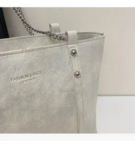 Detail of pearl silver leather tote with metallic texture and fashion bag logo engraving