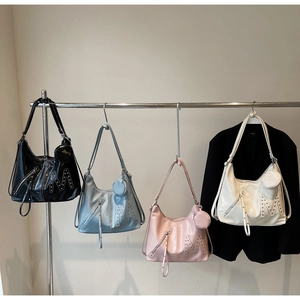 Close-up of four colors of retro hobo bags with silver studded M letter and mini charms