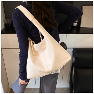 Detailed close-up of creamy white lychee grain leather tote with wide shoulder strap
