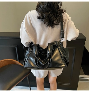 Detailed view of black vintage leather tote bag with double handles and side pockets