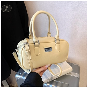 Detailed view of the textured pale yellow leather Boston bag with silver hardware accents